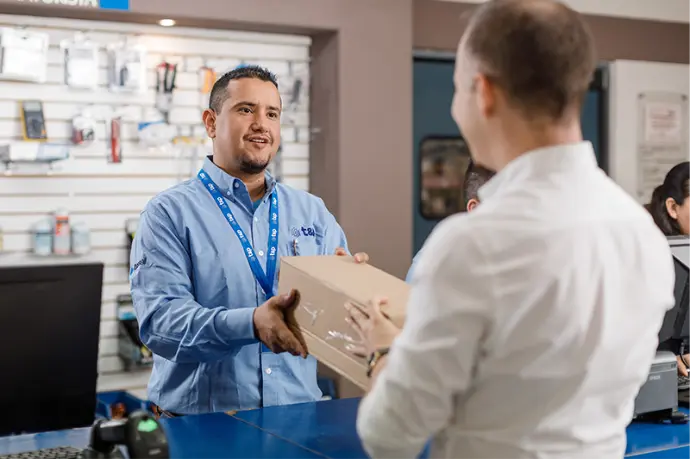 Vendedor de sucursal entregando paquete de producto a cliente Vendedor de sucursal entregando paquete de producto a cliente